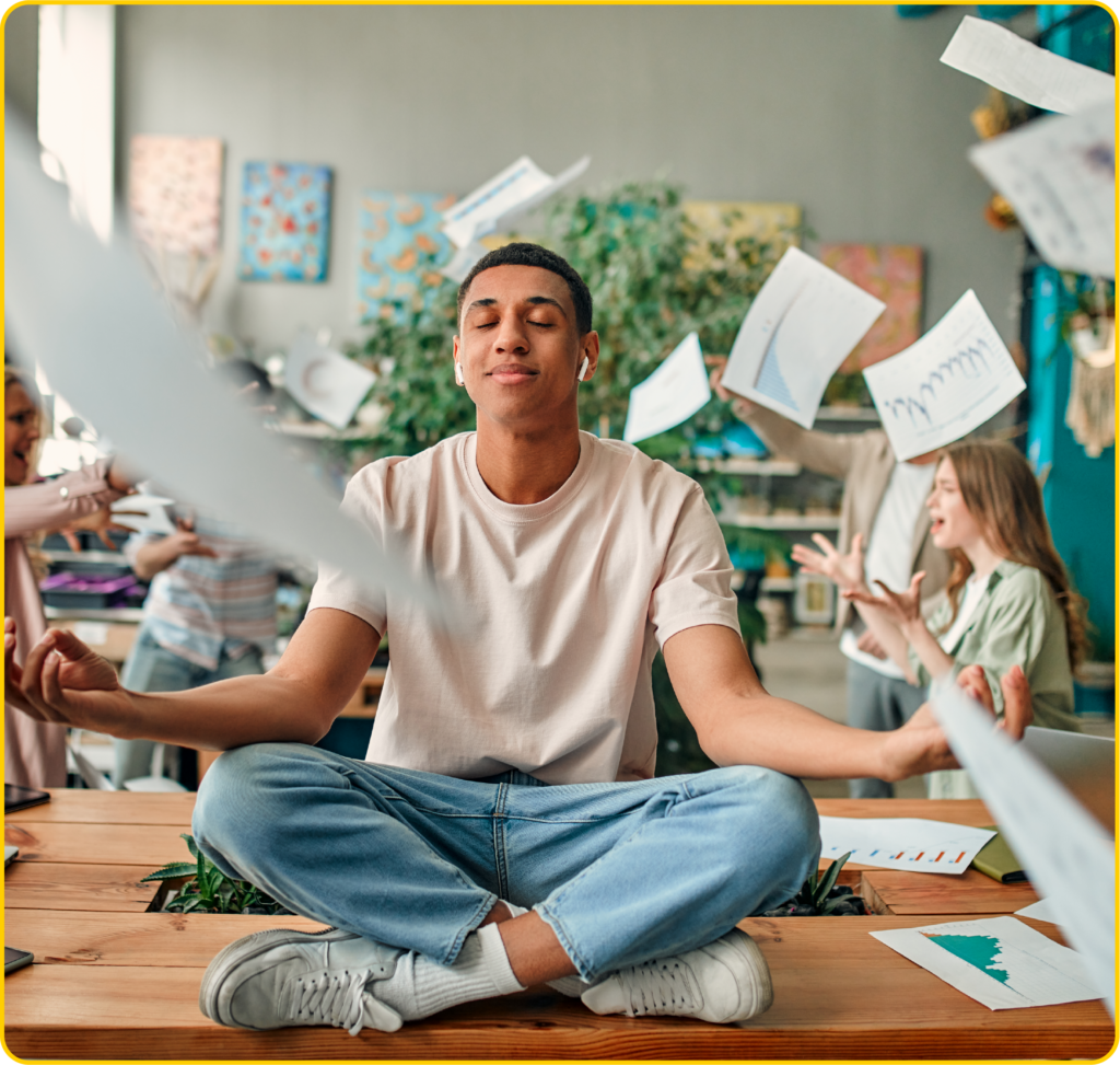 Jovem meditando no ambiente de trabalho, simbolizando bem-estar, equilíbrio emocional e prevenção do burnout em meio à rotina estressante.