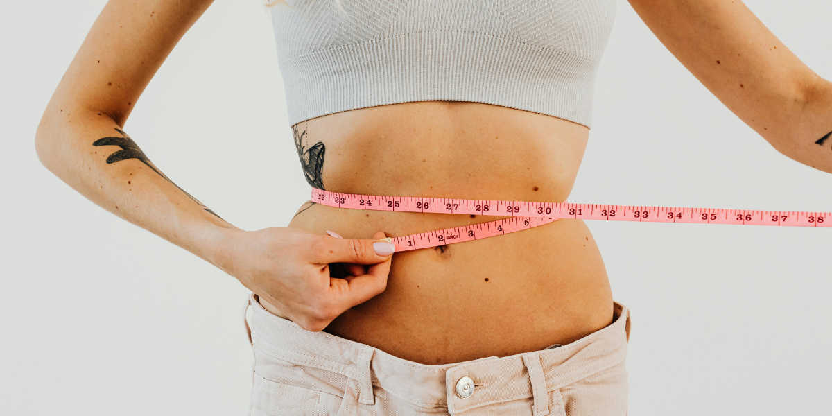 Mulher com fita métrica na cintura